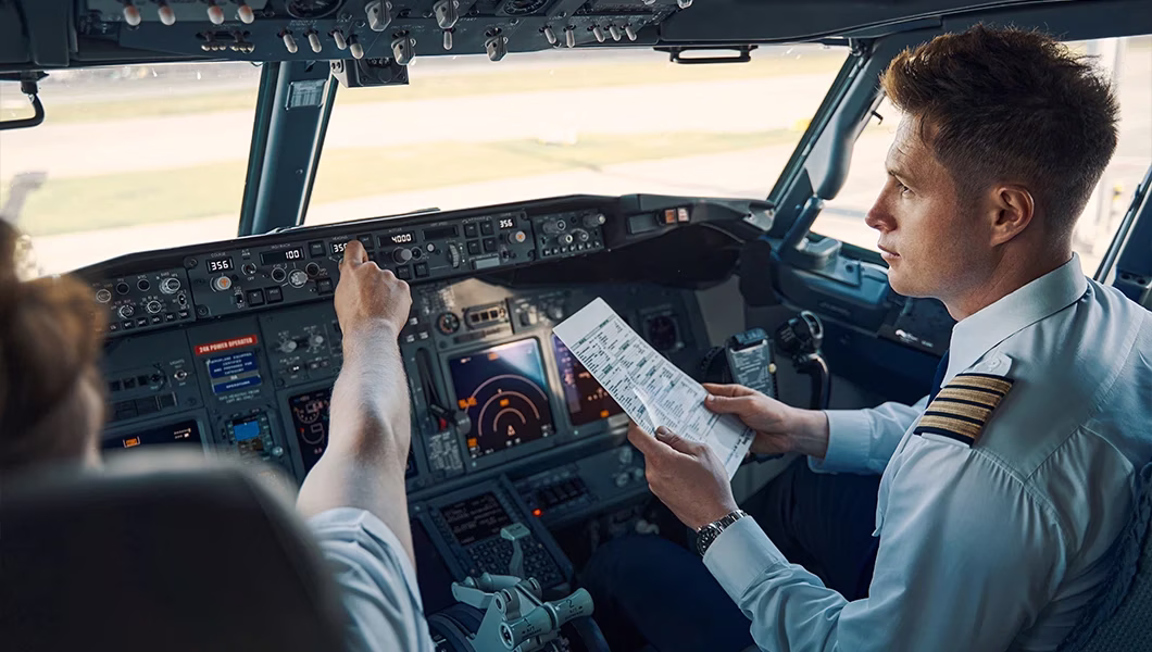 Pilots sitting in a cockpit, going through procedures.