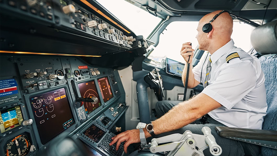 Pilot speaking on a radio transmitter in an aircraft.