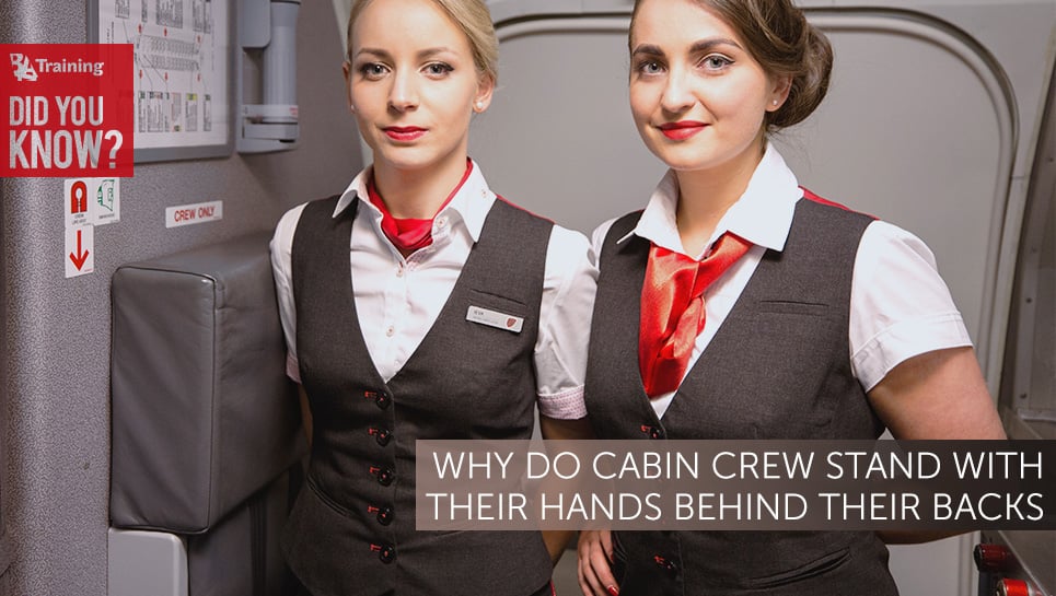 why do cabin crew stand with their hands behind their backs