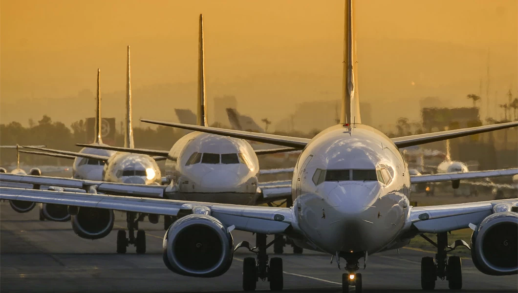 four aircraft lined up on a taxiway at an airport