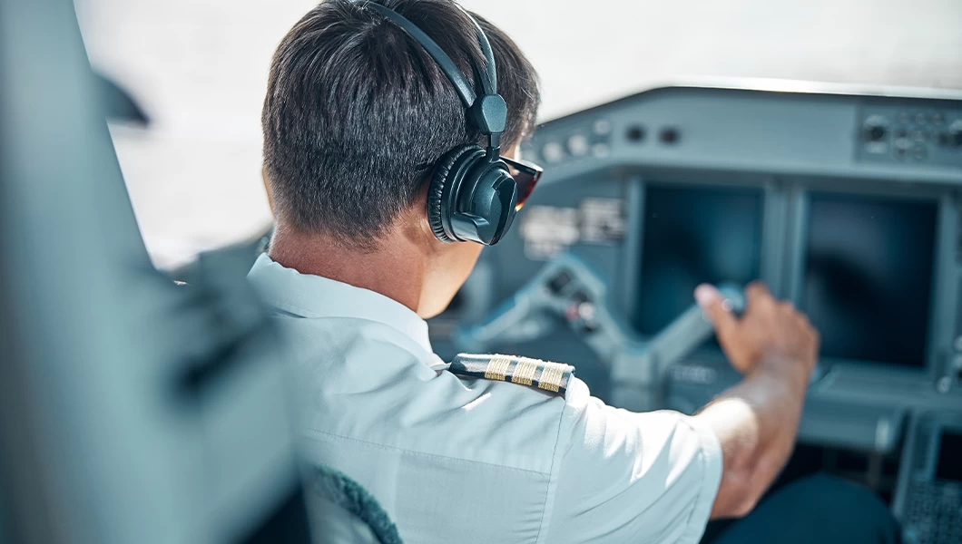 A pilot in a cockpit with a headset on