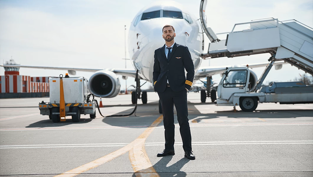 A pilot standing in front of an airplane.