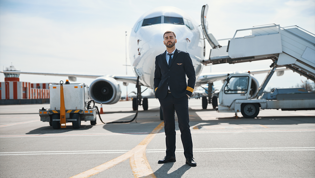 Airline pilot standing next to an airplane