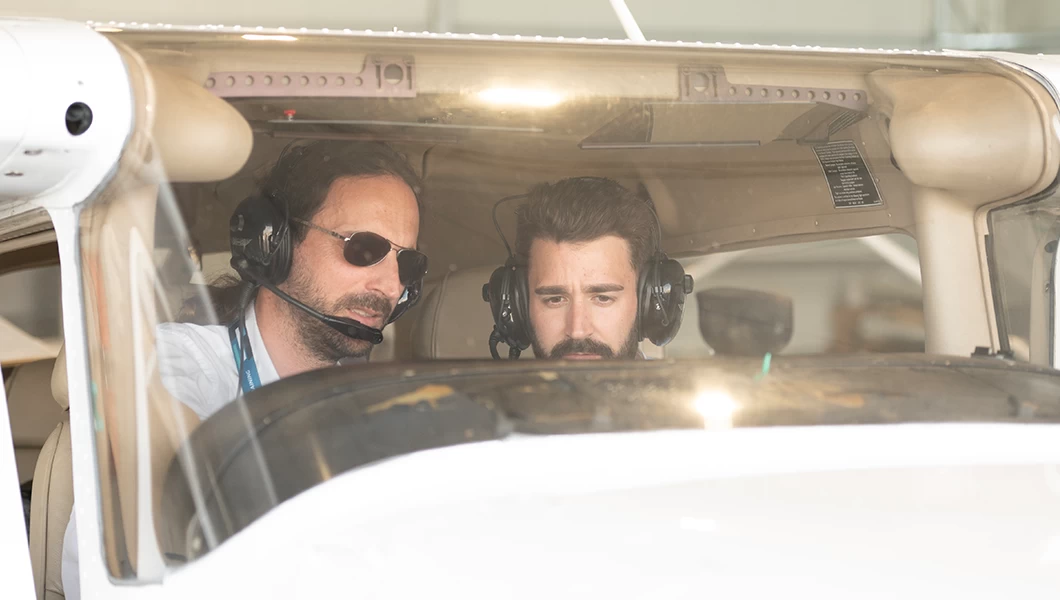 Two pilots sitting inside a single-engine aircraft