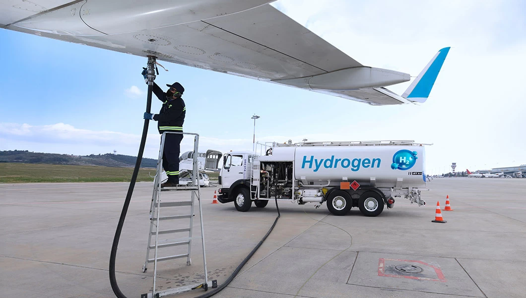 An aviation biofuel cistern with a ground handling staff filling up the aircraft with fuel